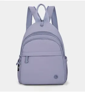 Detailed front view of lavender nylon backpack with multi-layer zipper compartments