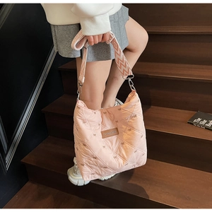 Détail du sac cabas rose matelassé avec broderie nœud et patch en cuir griffé