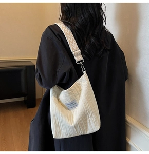 Détail du sac fourre-tout matelassé blanc avec bandoulière géométrique et étiquette