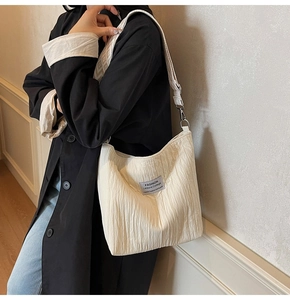 Détail d'un sac cabas plissé blanc cassé avec une bandoulière en jacquard