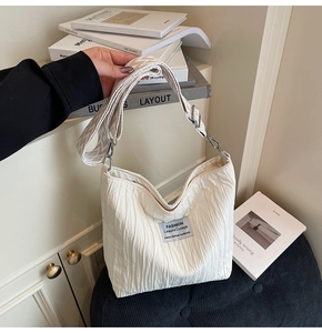 Gros plan d'un sac cabas plissé blanc avec bandoulière en jacquard et boucle métallique