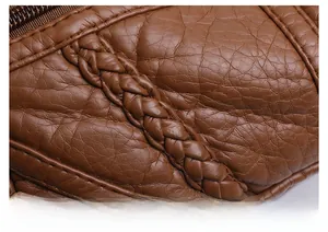 Macro detail of brown litchi pattern PU leather texture with woven decorative strap