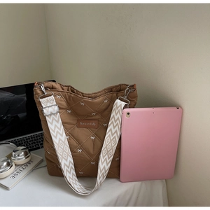 Sac cabas marron matelassé avec broderie nœud et bandoulière géométrique large détail