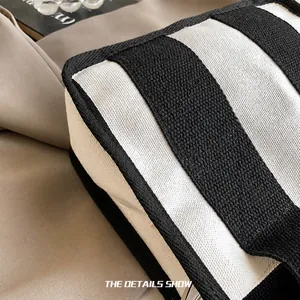 Detailaufnahme der schwarz-weiß gestreiften Canvas-Tasche mit präziser Nahtverarbeitung