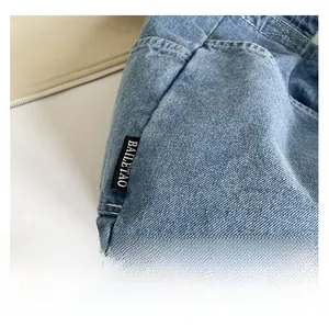 Detailed macro view of light blue denim fabric texture with neat white double stitching