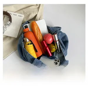 Top-down view of spacious denim tote bag interior holding umbrella and essentials