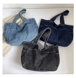 Close-up of three denim tote bags in light blue, dark blue and grey black colors