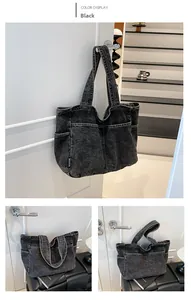 Detail of black washed denim tote bag featuring functional side pockets and woven label