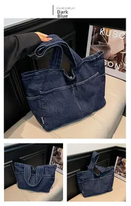Detail of dark blue denim tote bag with contrast stitching and multi-pocket design