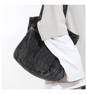 Detail of washed denim tote bag showing side pocket texture and retro fabric finish