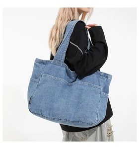 Close-up of light blue denim tote bag with side pocket and detailed stitching