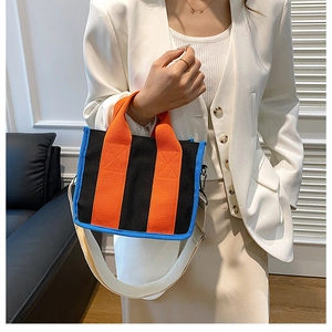 Detailansicht einer Canvas-Tragetasche mit orangefarbenen Trägern und blauer Paspelierung
