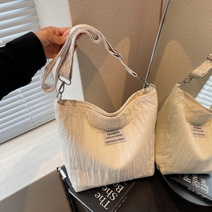 Beige pleated canvas tote bag with wide jacquard shoulder strap for casual daily commuting