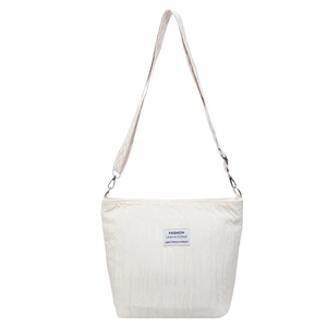 Minimalist beige canvas tote bag with pleated texture and wide geometric shoulder strap