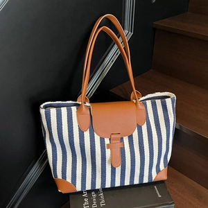 Large capacity striped canvas tote bag with brown leather accents and a casual style