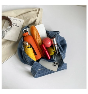 Top view showing the spacious interior of this blue denim tote bag with various items