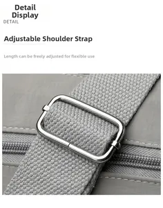 Close-up of a wide grey woven shoulder strap with a silver adjustable metal buckle