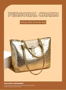 Detail of gold tote bag featuring ostrich embossed texture and khaki leather corners