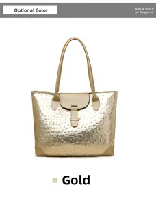 Detail of gold tote bag featuring ostrich skin texture and long brown carry handles