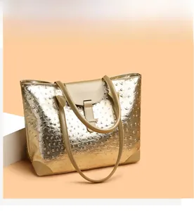 Detail of champagne gold tote bag featuring ostrich texture and slim shoulder straps