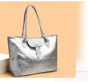 Detail of silver ostrich pattern tote bag with metallic finish and metal buckle closure