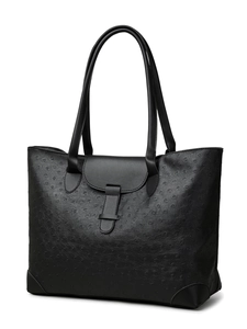 Detail of black ostrich embossed faux leather tote bag showing texture and buckle closure