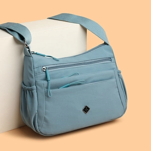 Fog blue nylon crossbody bag with multi-layer zipper pockets and wide shoulder strap