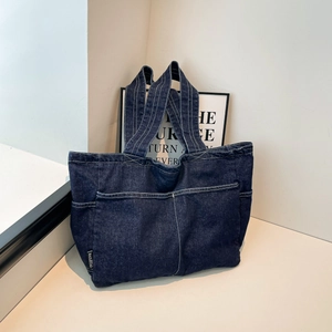 Large dark blue denim tote bag with white contrast stitching and front pockets