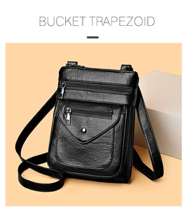 Detail of black pebbled leather crossbody phone bag with multiple metal zippers and front flap