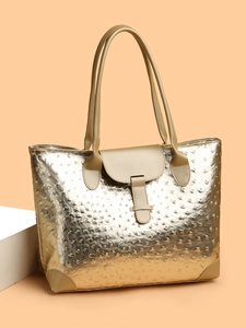 Detail of gold ostrich pattern tote bag with reinforced corners and buckle closure