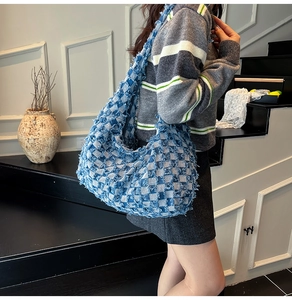 Detail of blue and white checkered denim tote bag featuring vintage frayed edge textures