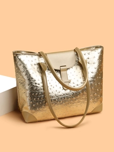Close-up of gold tote bag featuring premium ostrich leather texture and buckle detail