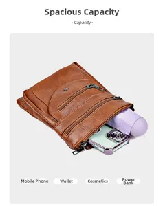 Detail of a brown leather crossbody phone bag with three zippers showing large capacity