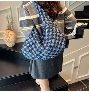 Close-up of blue and white checkered denim tote bag with frayed fringe detail