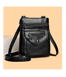 Detail of black PU leather crossbody bag featuring multiple zippers and a snap flap pocket