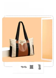 Close-up of quilted nylon tote bag with brown leather trim and black woven shoulder strap