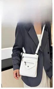 White faux leather crossbody bag with dual zipper compartments shown on a model