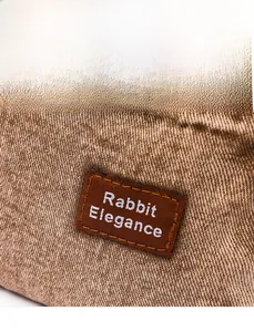 Close-up of Rabbit Elegance label on vintage washed denim crossbody bag with fine stitching