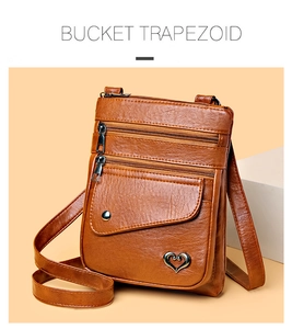 Brown lychee leather crossbody bag detail with heart metal charm and zipper pockets