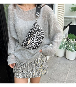 Détail du sac banane léopard avec bandoulière réglable porté par un mannequin extérieur