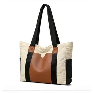 Detailed side view of a quilted nylon tote bag with brown leather contrast and black strap