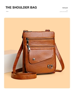 Macro view of vintage brown pebbled leather bag with triple zippers and heart metal accent