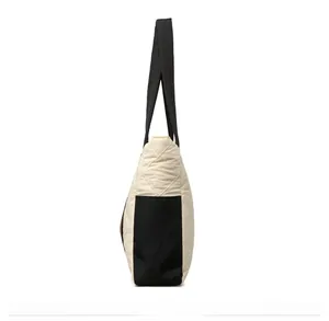 Side view of quilted nylon tote bag with black contrast trim and wide storage depth