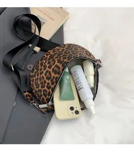 Intérieur du sac bandoulière léopard montrant l'espace pour téléphone et cosmétique