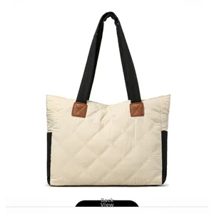 Back view of a quilted nylon tote bag featuring beige fabric and black contrast stitching