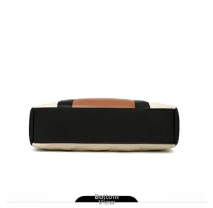 Detailed bottom view of the quilted nylon handbag showing durable black base and contrast beige
