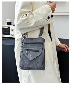 Close-up of grey vintage crossbody phone bag with multiple zippers on model