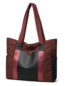 Detailed view of quilted nylon handbag with diamond patterns and woven handles