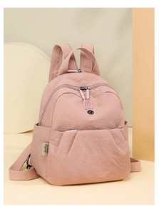 Details des wasserabweisenden rosa Nylon-Rucksacks mit Textur und seitlichem Markenlabel