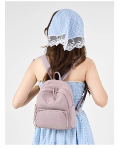 Detail of light purple nylon backpack showing Modifei logo and textile texture